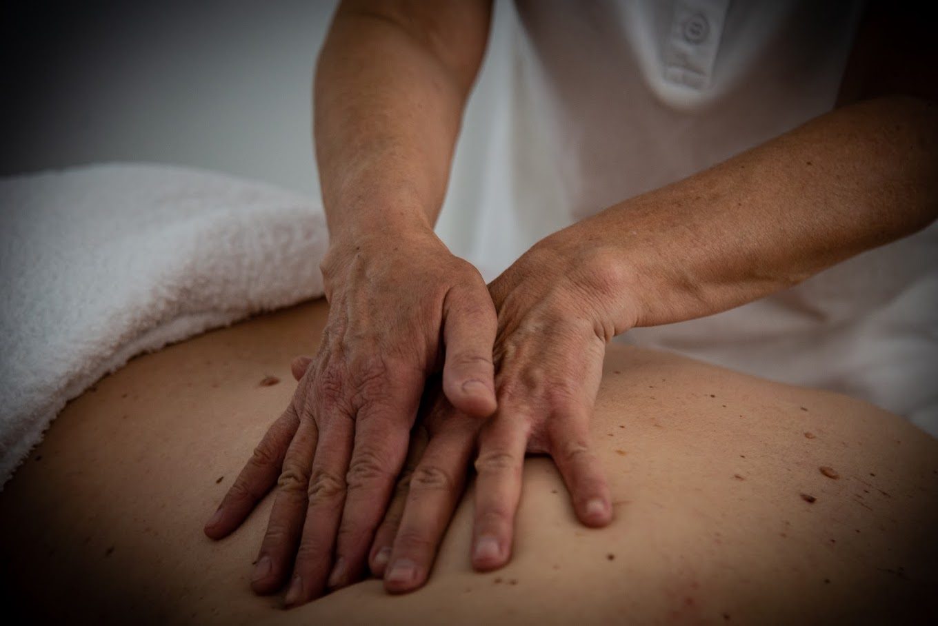 Mani di un operatore di Studio Olistico Metamorfosi durante un massaggio alla schiena